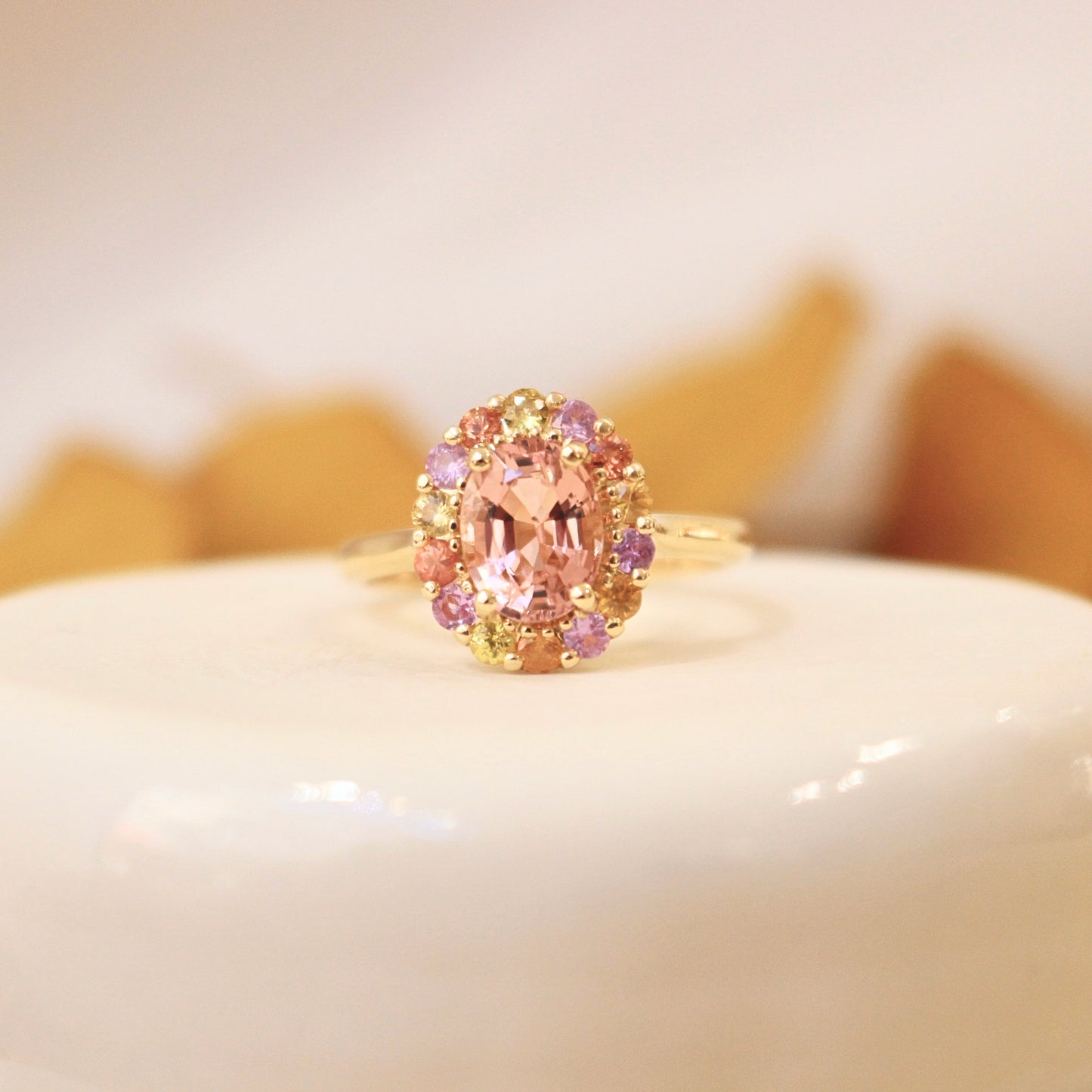 bague entourage tourmaline rose et saphirs multicolores sur une monture en or jaune