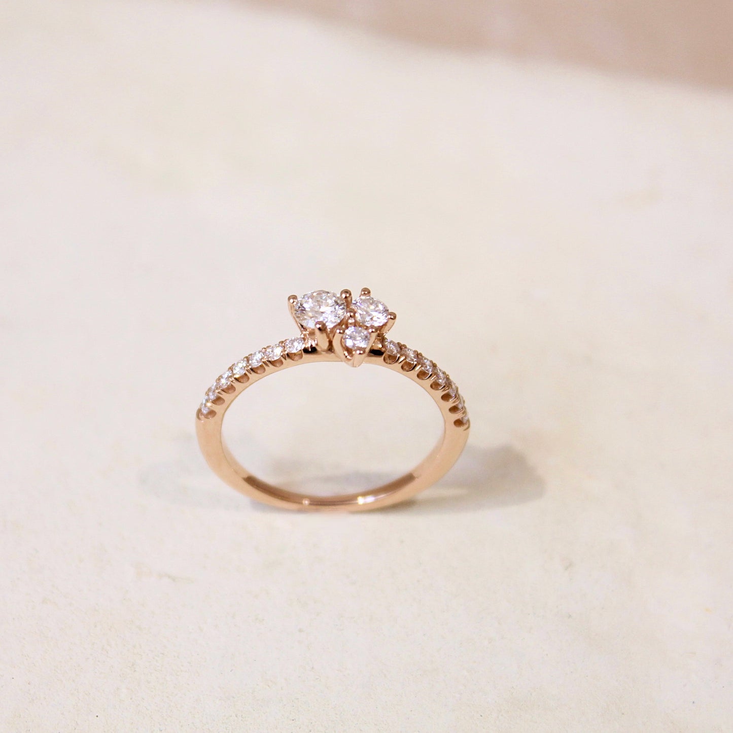 Bague en or rose et diamants- trois diamants taille brillant au centre et un anneau pavé de diamants