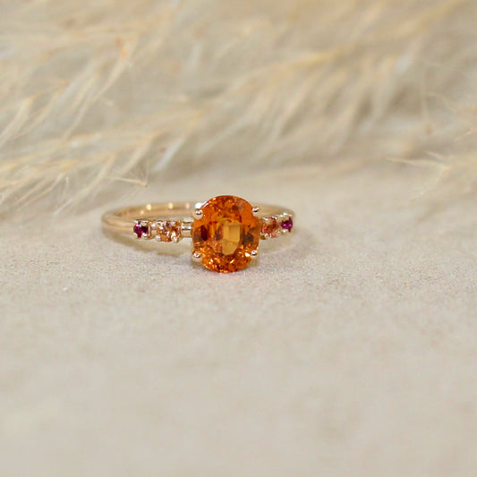 bague spessartite accompagné de rubis et de saphirs sur une monture en or rose