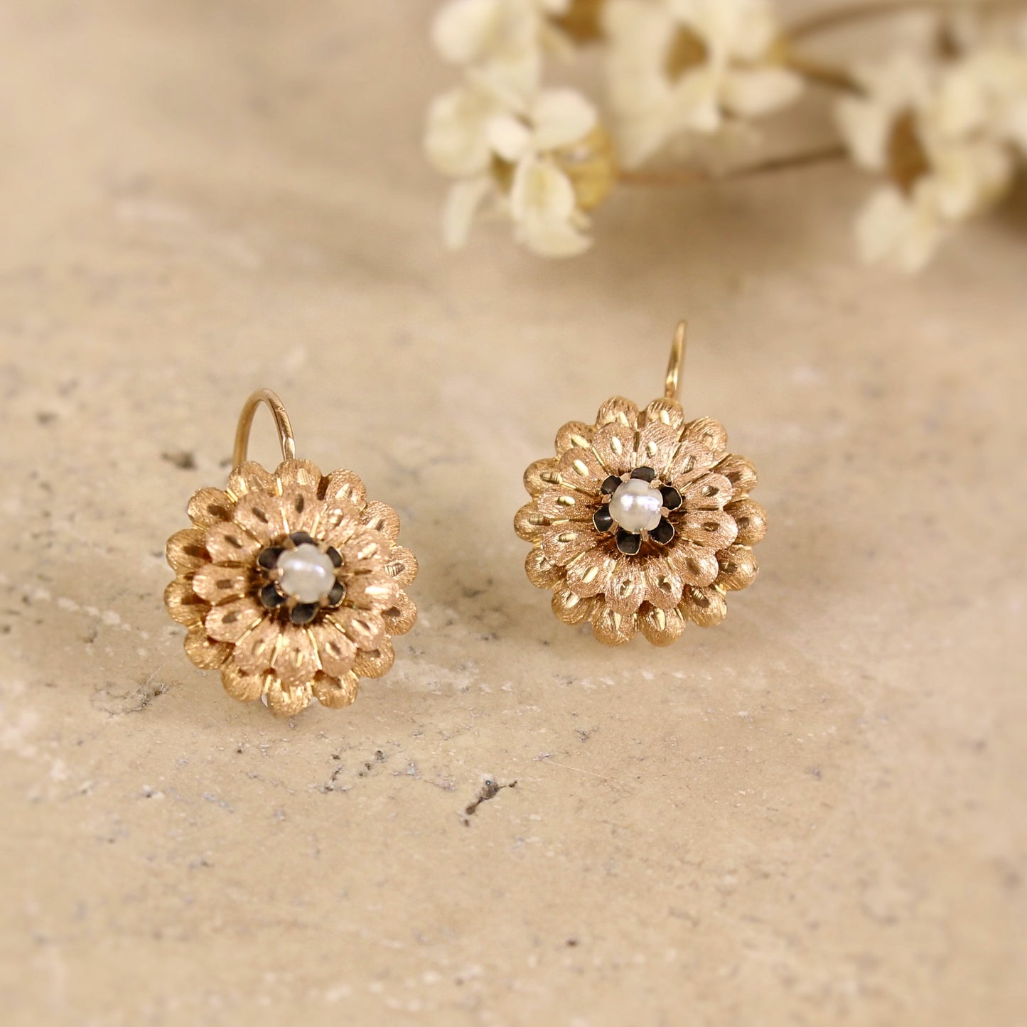 Boucles d'oreilles anciennes formant une fleur ornée d'une perle au centre. Délicat travail de l'or-systeme dormeuses