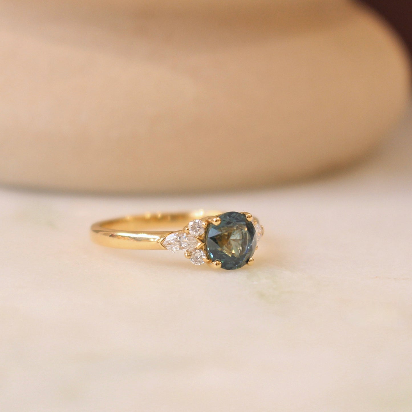 bague de fiançailles ornée d'un saphir vert et de diamants navette et ronds-monture en or jaune 18k