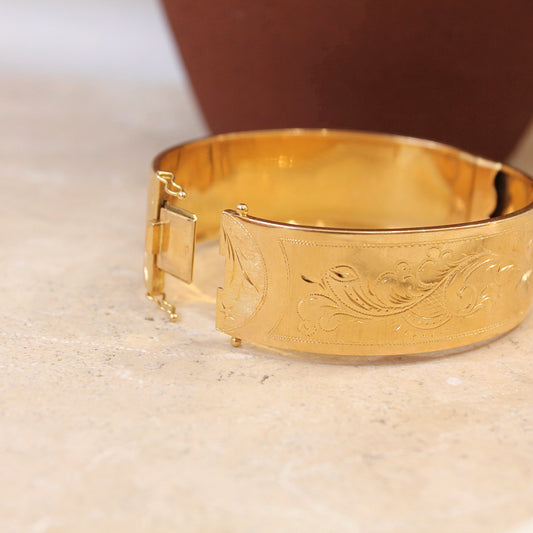 bracelet ancien type manchette en or jaune- ouverture système cliquet-décor floral ciselé