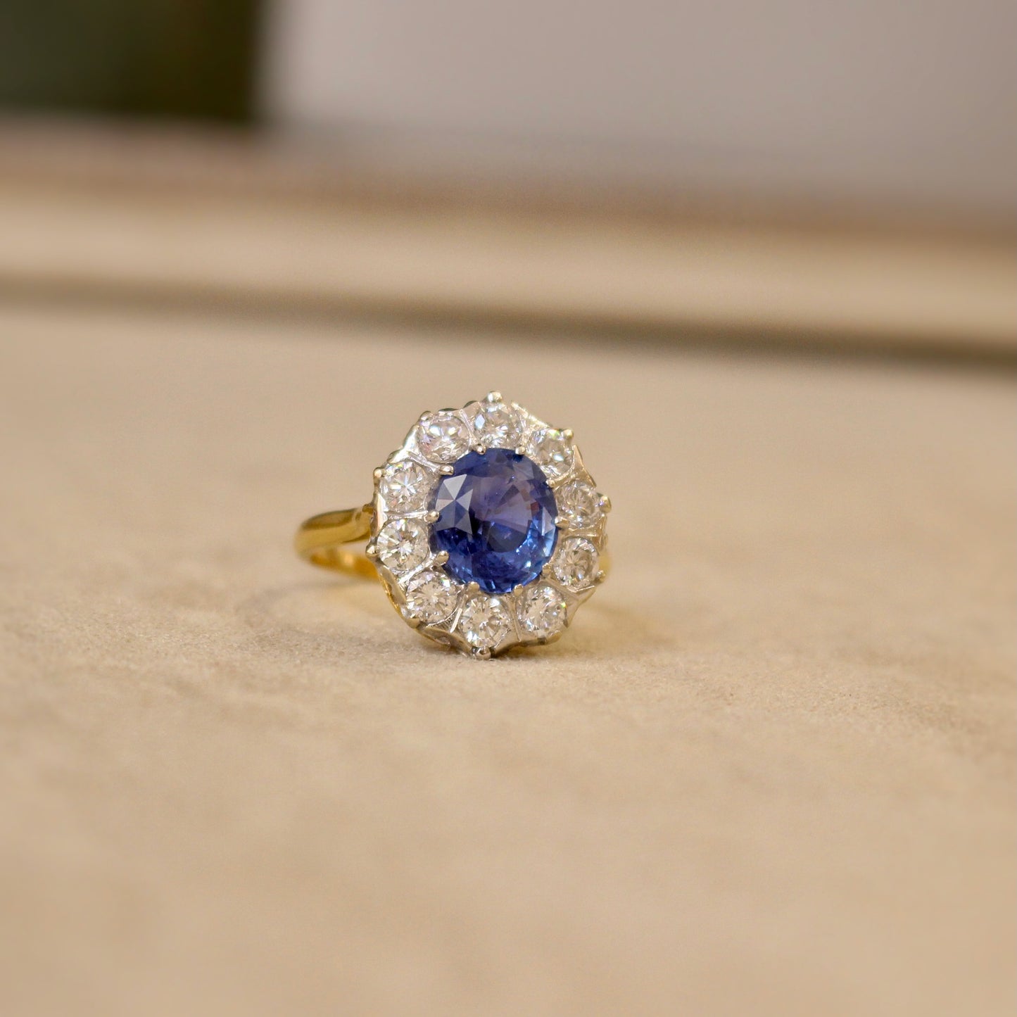 Un saphir de Ceylan exceptionnel entouré de diamants compose cette bague marguerite- bague de fiançailles parfaite