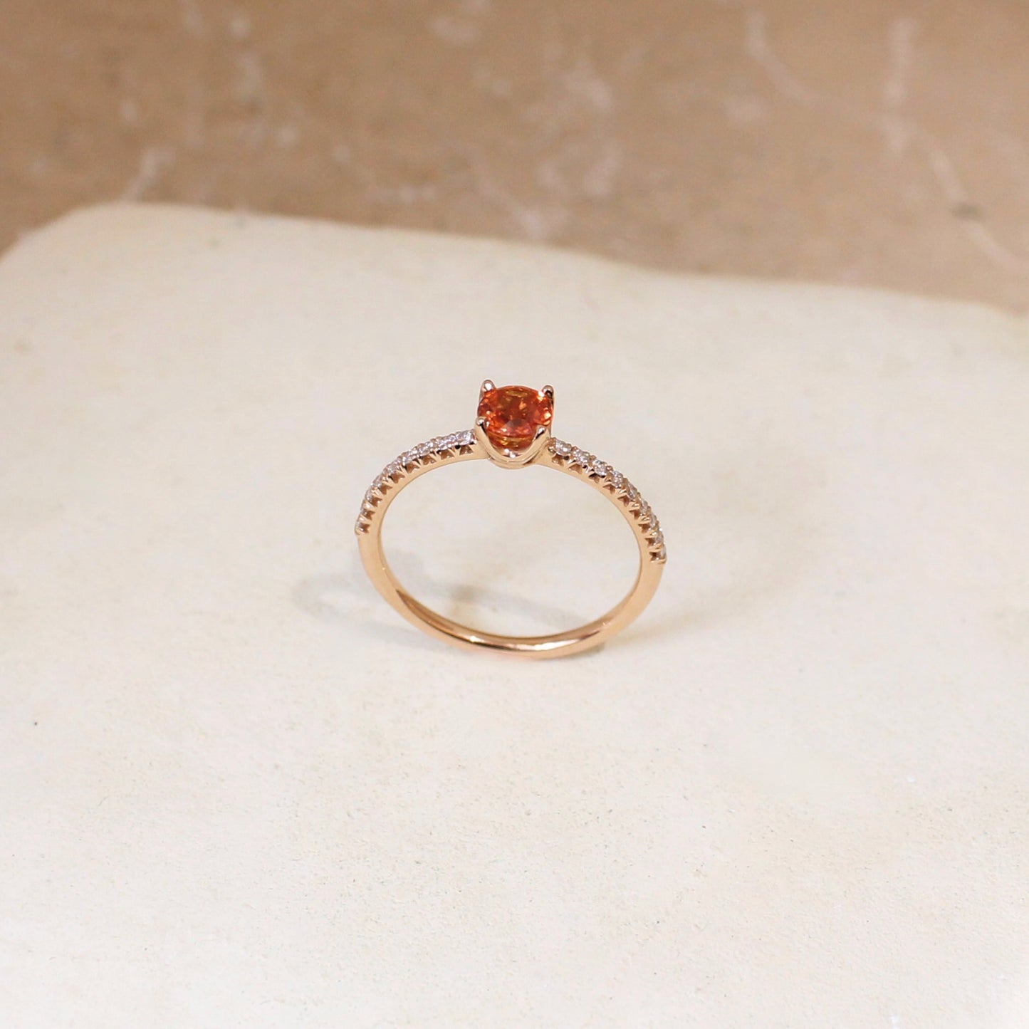 Une bague fine et colorée grace à son saphir orange intense au centre rehaussé par une ligne de diamants