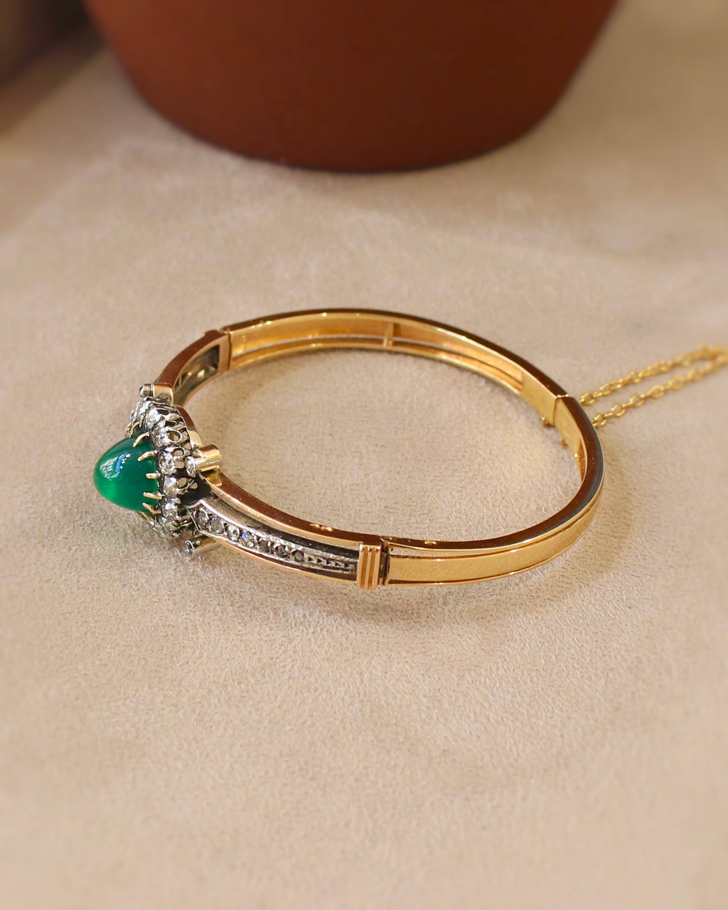 vue de coté d'un bracelet ancien - jonc ouvrant en or rose et argent avec cabochon de chrysopase entouré de diamants