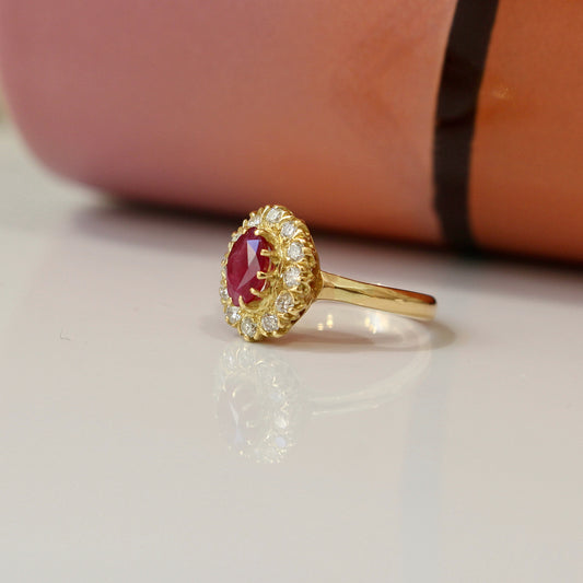 bague marguerite ornée d'un rubis en son centre entièrement entouré de diamants, monture en or jaune 18k