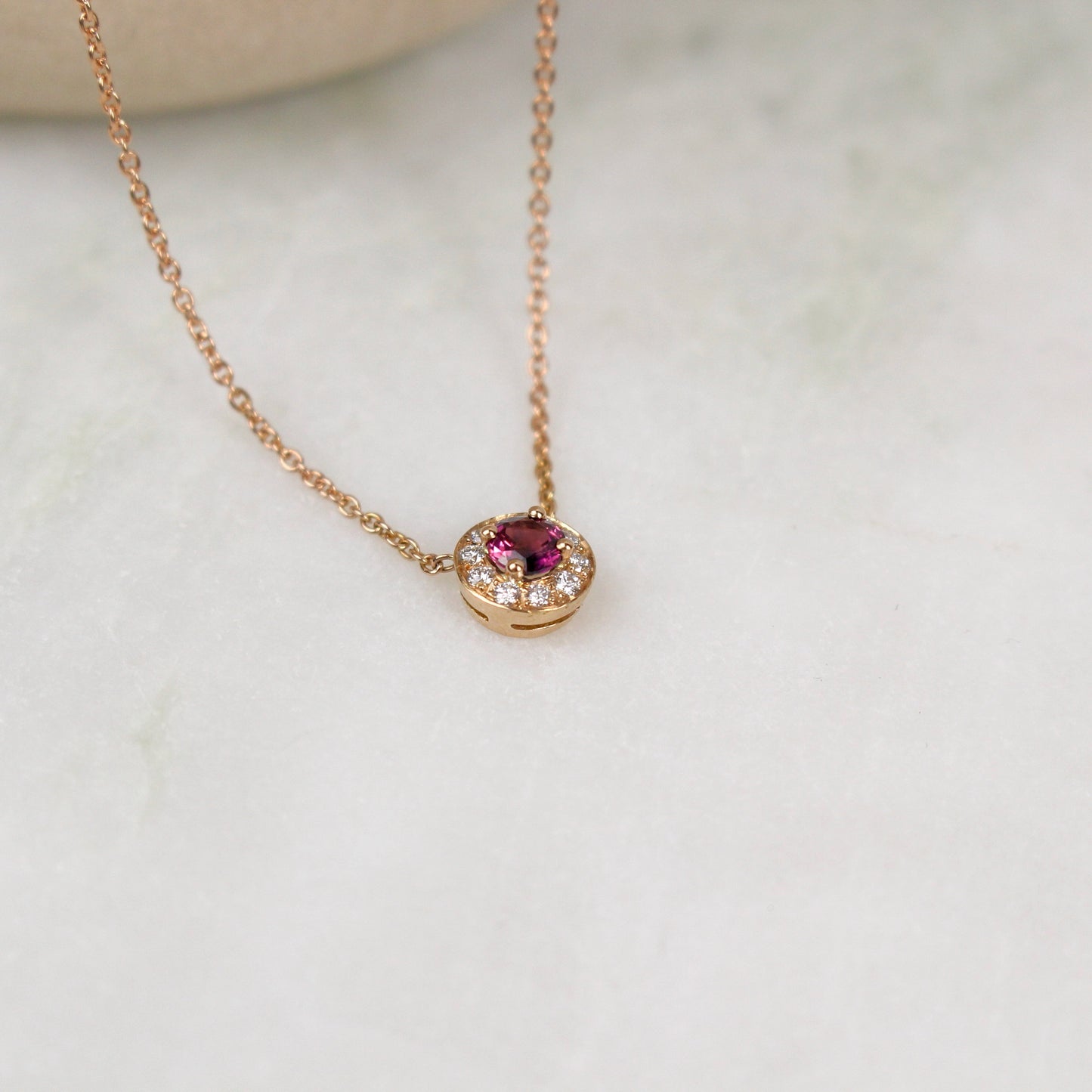 Tres beau pendentif en or rose avec au centre un saphir rose entierement entoure de diamants