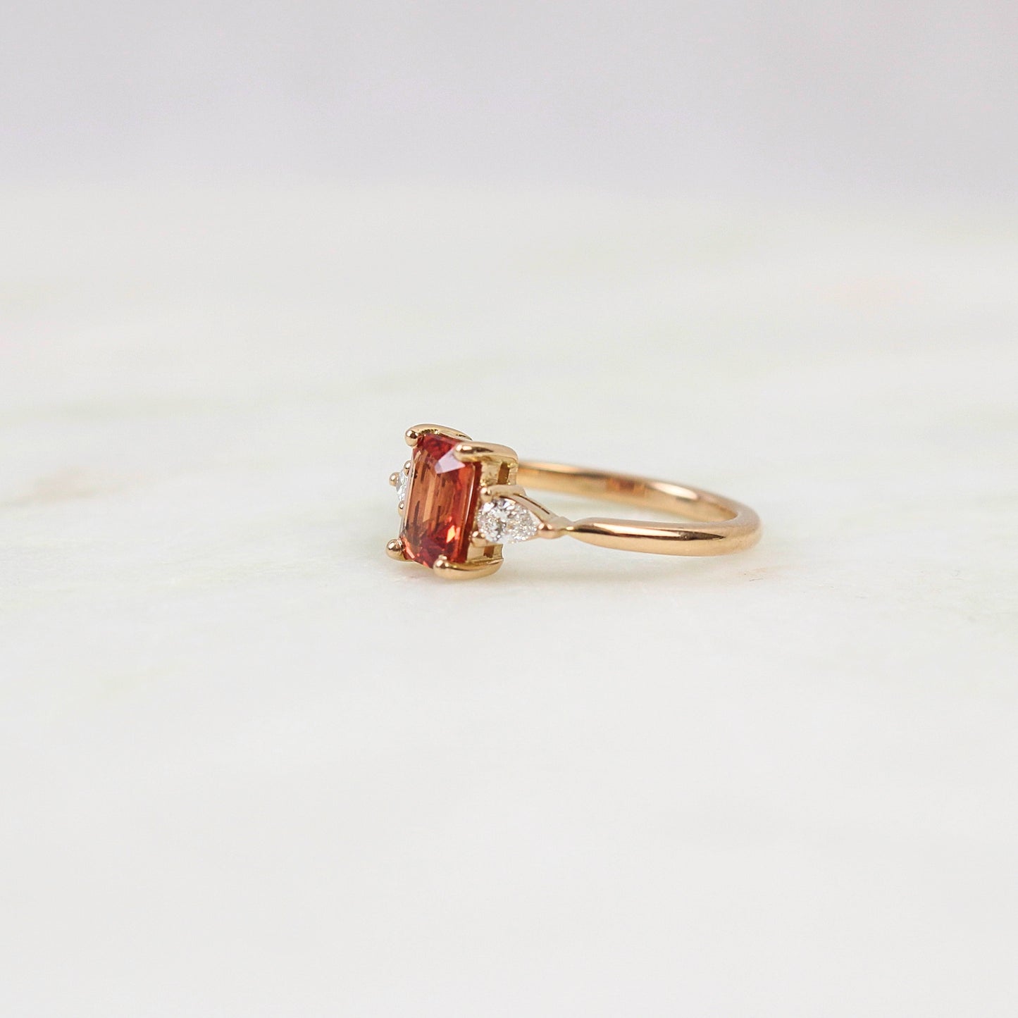 superbe saphir orange en taille emeraude avec diamants taille poire sur une monture en or rose1 8k