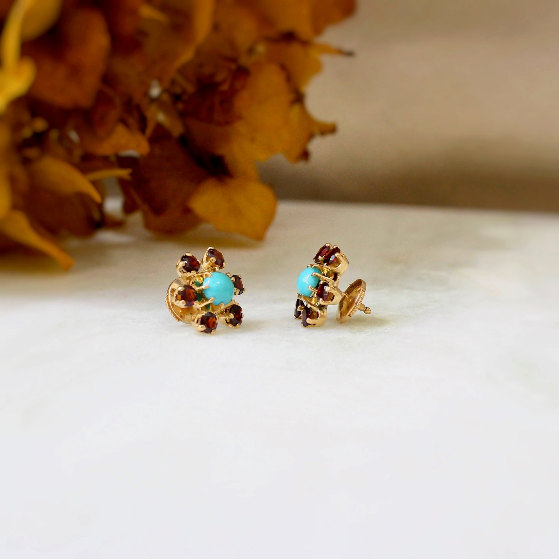 puces d'oreilles fleurs avec turquoise et grenats sur une monture en or jaune 18k