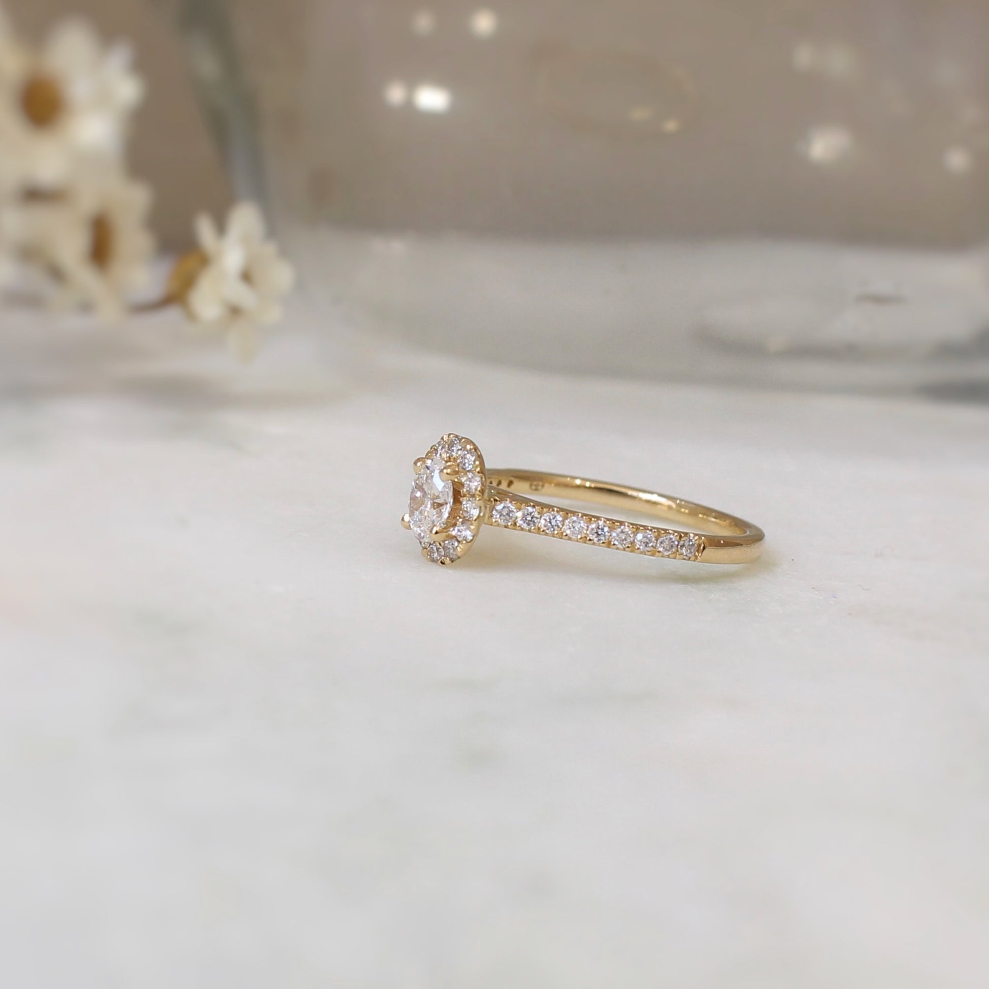 Bague de fiançailles avec au centre un diamant oval entouré de