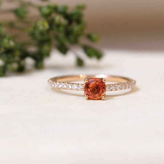 solitaire pour femme avec au centre un saphir orange taille brillant avec un anneau pavé de diamants