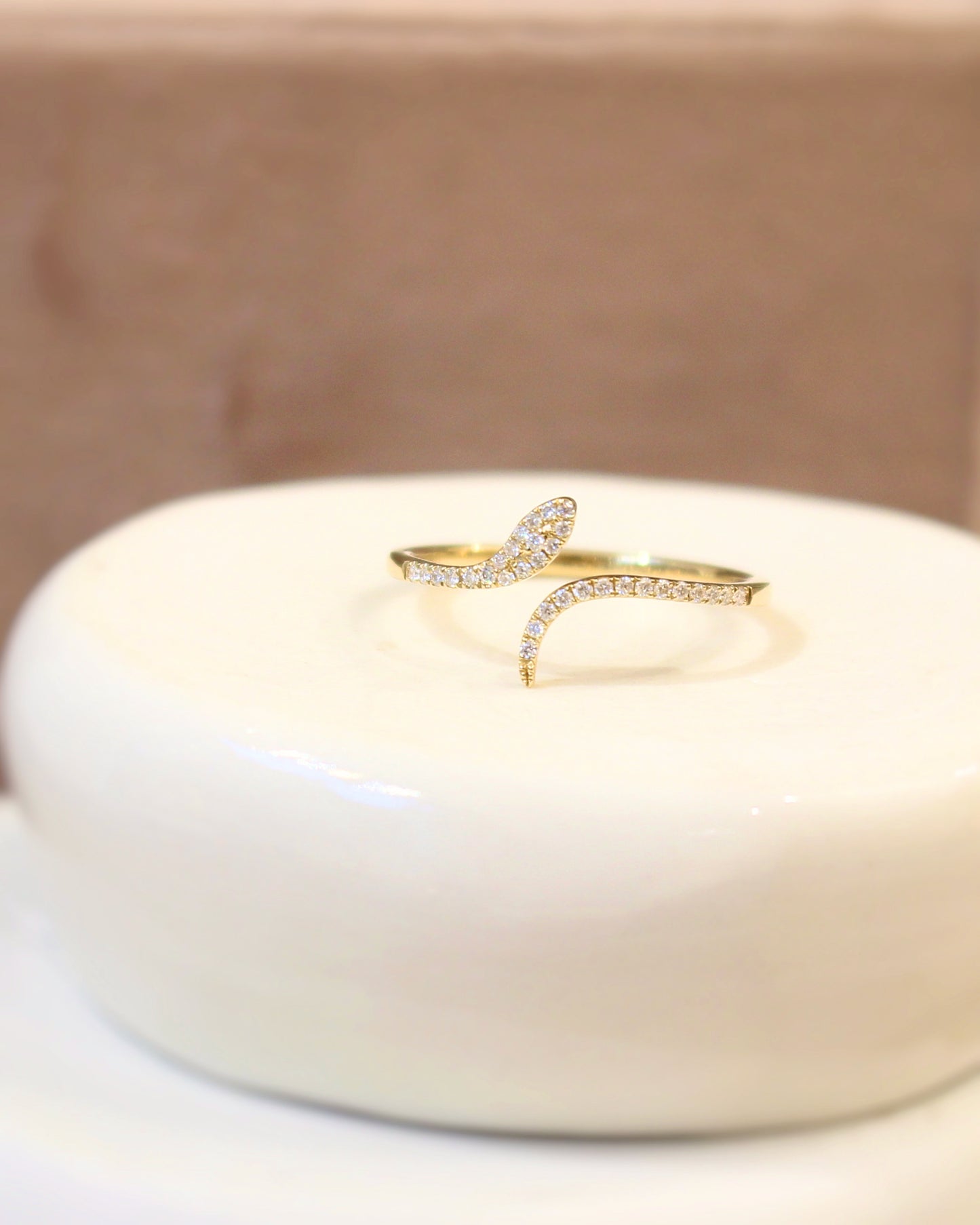 bague serpent en or jaune sur une monture pavée de diamants
