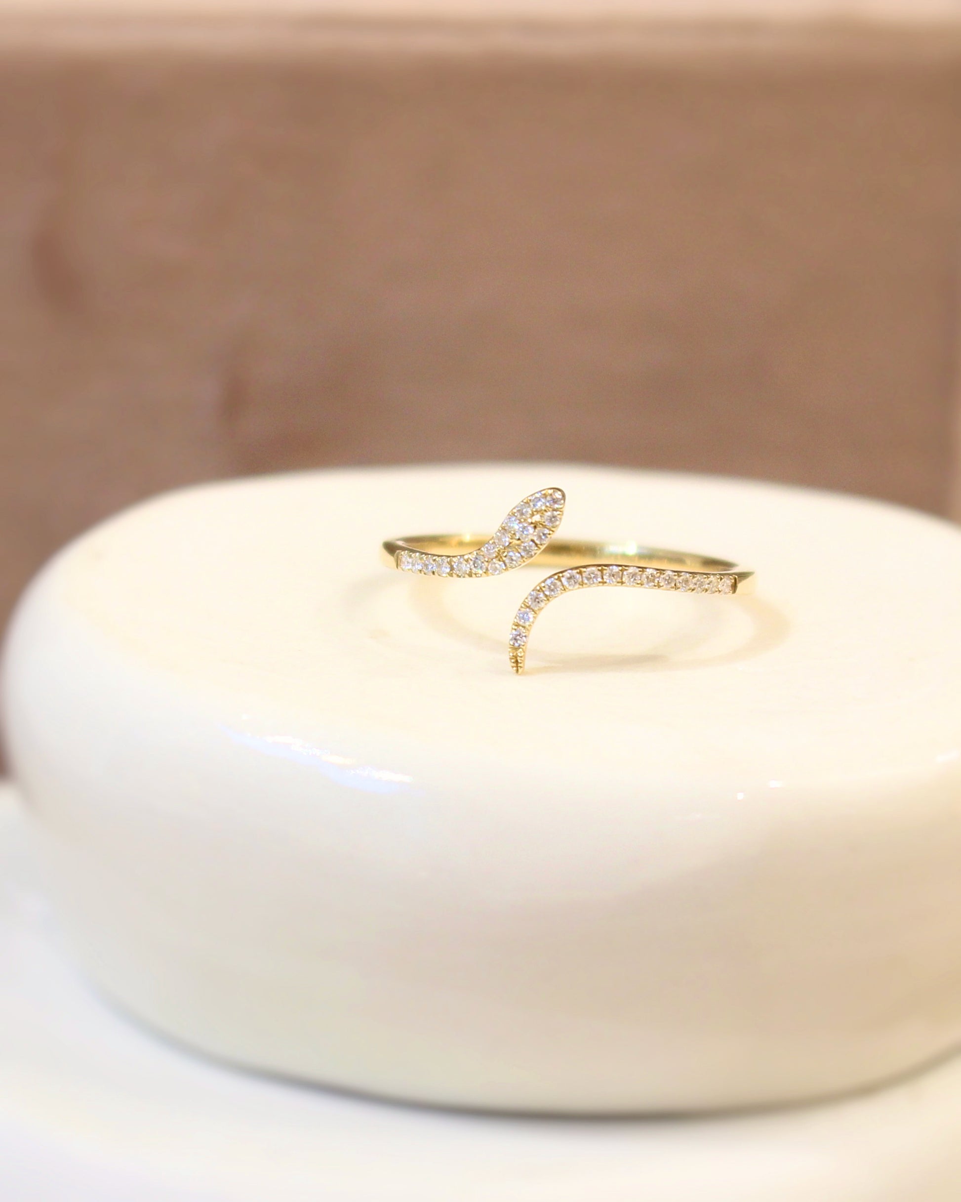 bague serpent en or jaune sur une monture pavée de diamants
