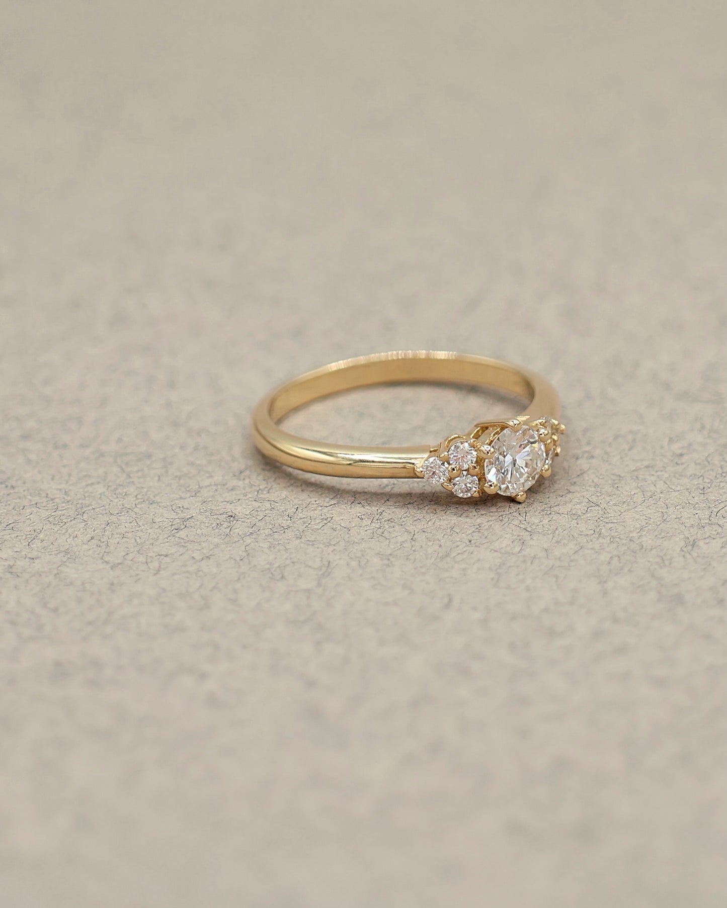 bague_solitaite_diamant_epaule_d_une_trilogie_de_diamants_sur_une_monture_en_or_jaune