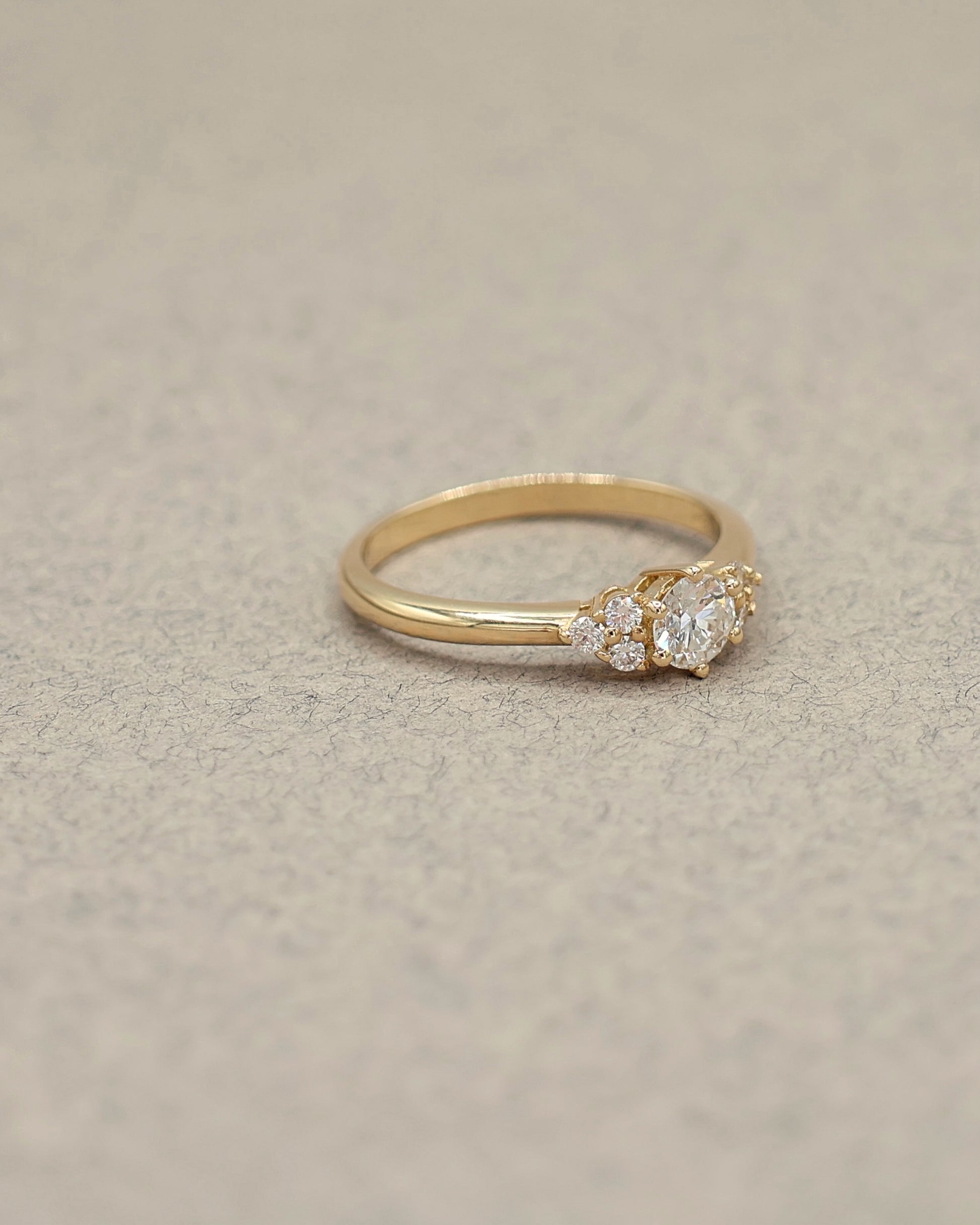 bague_solitaite_diamant_epaule_d_une_trilogie_de_diamants_sur_une_monture_en_or_jaune