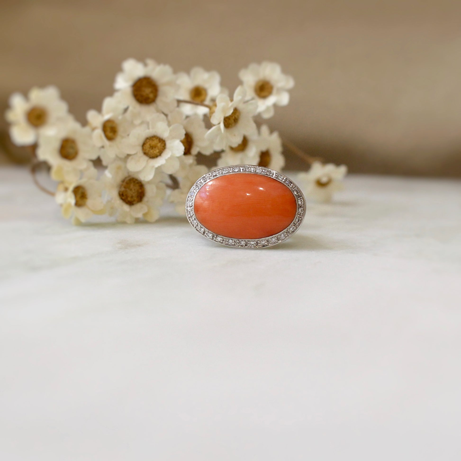 bague chevalière d'occasion pour femme avec important cabochon de corail et un entourage de diamants-monture en or blanc 18k