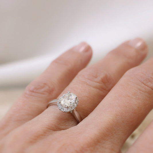bague de demande en mariage-diamant ovale de 0,72 carat entouré de xdiamants taille brillants sur une monture en or blanc 18k