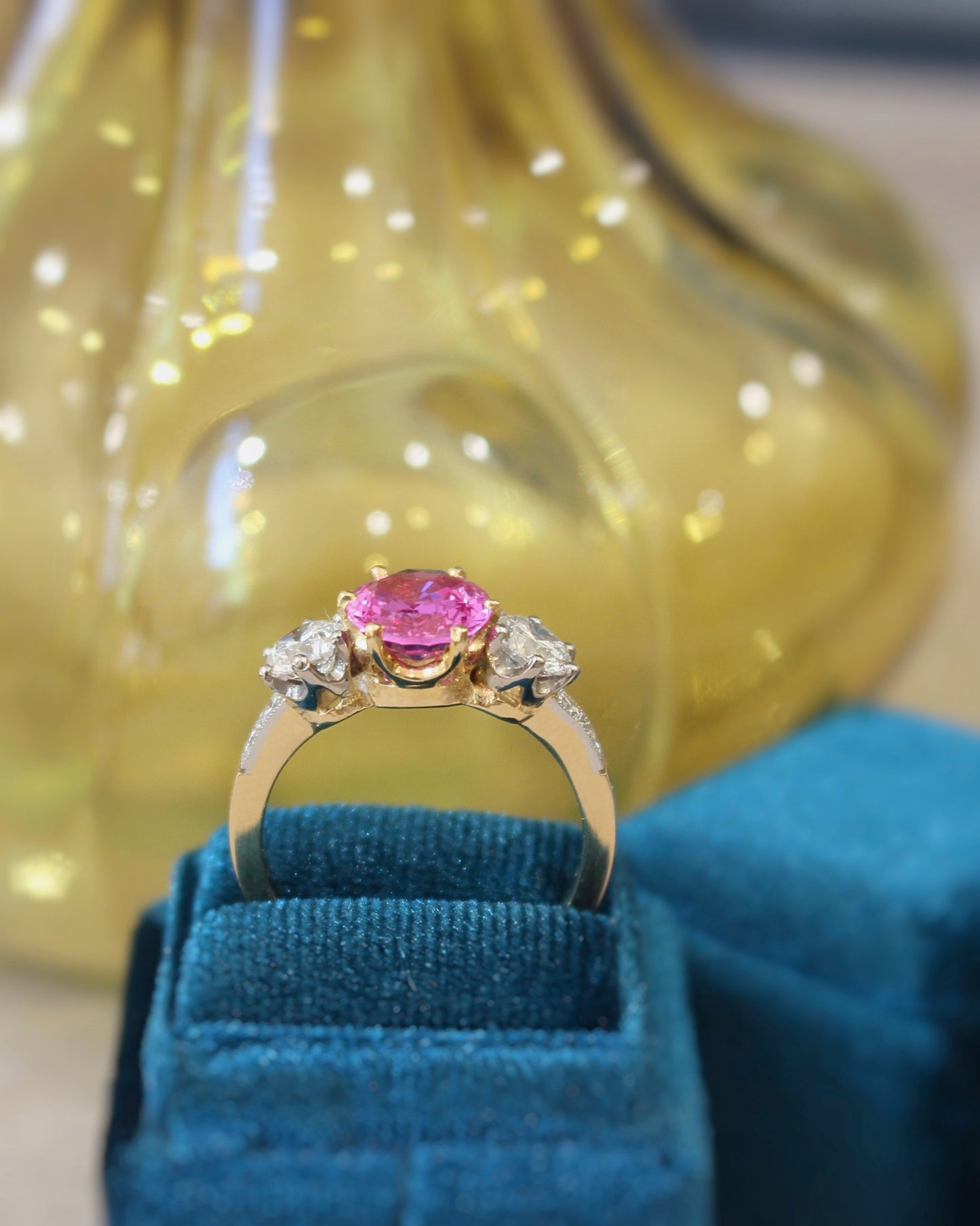 bague de fiançailles ornée d'un saphir rose taille ovale et de deux diamants taille brillant- monture en or jaune et platine