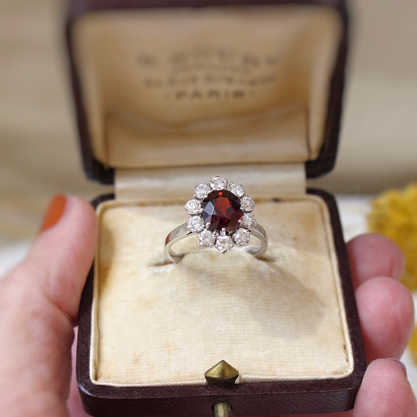 bague marguerite vintage avec au centre un grenat rhodolite entouré de 10 diamants taille brillant