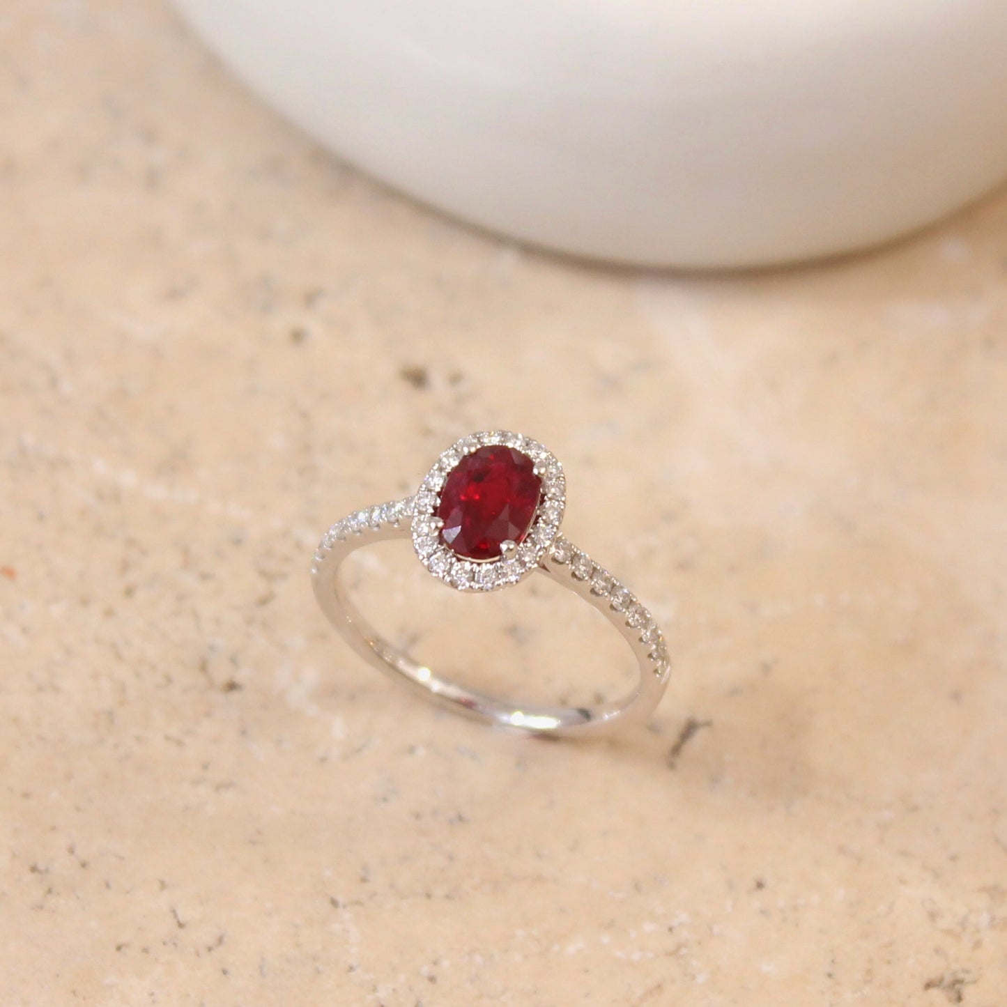 charmante bague de fiançailles composée d'un rubis taille ovale de 0,95 carat entouré de diamants-monture en or blanc pavée de diamants