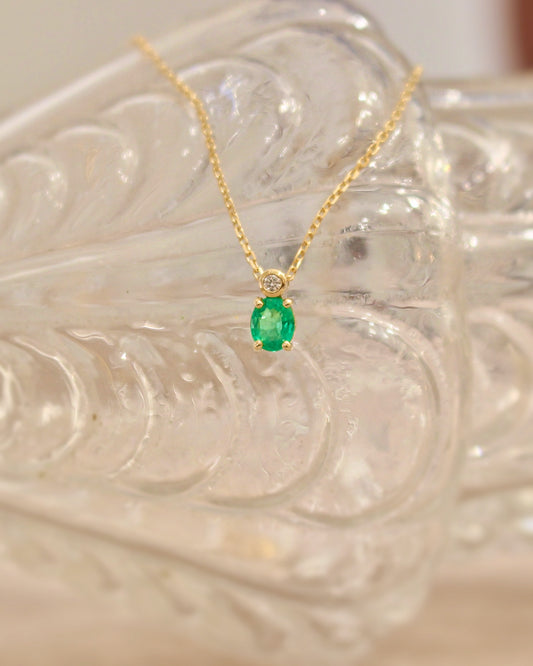 collier fin pour femme en or jaune ornée d'une émeraude et d'un diamant .