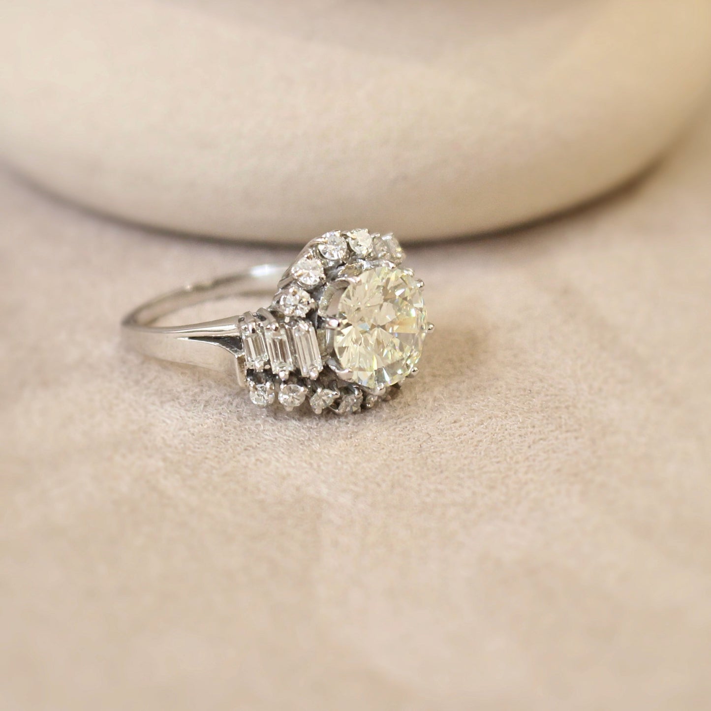 Impotante bague art déco avec au centre un diamant de 3 carats-volutes de diamants en entourage et diamants baguettes sur les cotés-monture en or blanc 18k