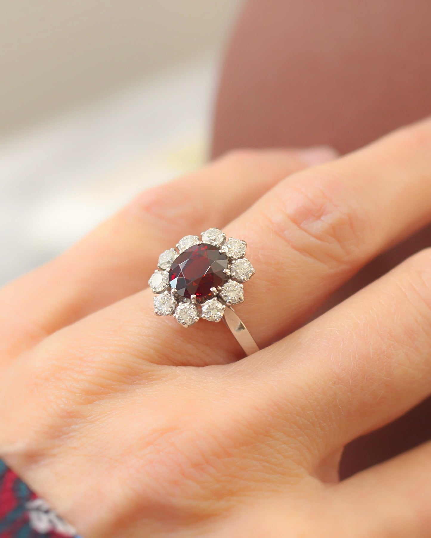 importante bague marguerite ornée d'un grenat taille ovale entourage diamants - monture en or blanc 18k
