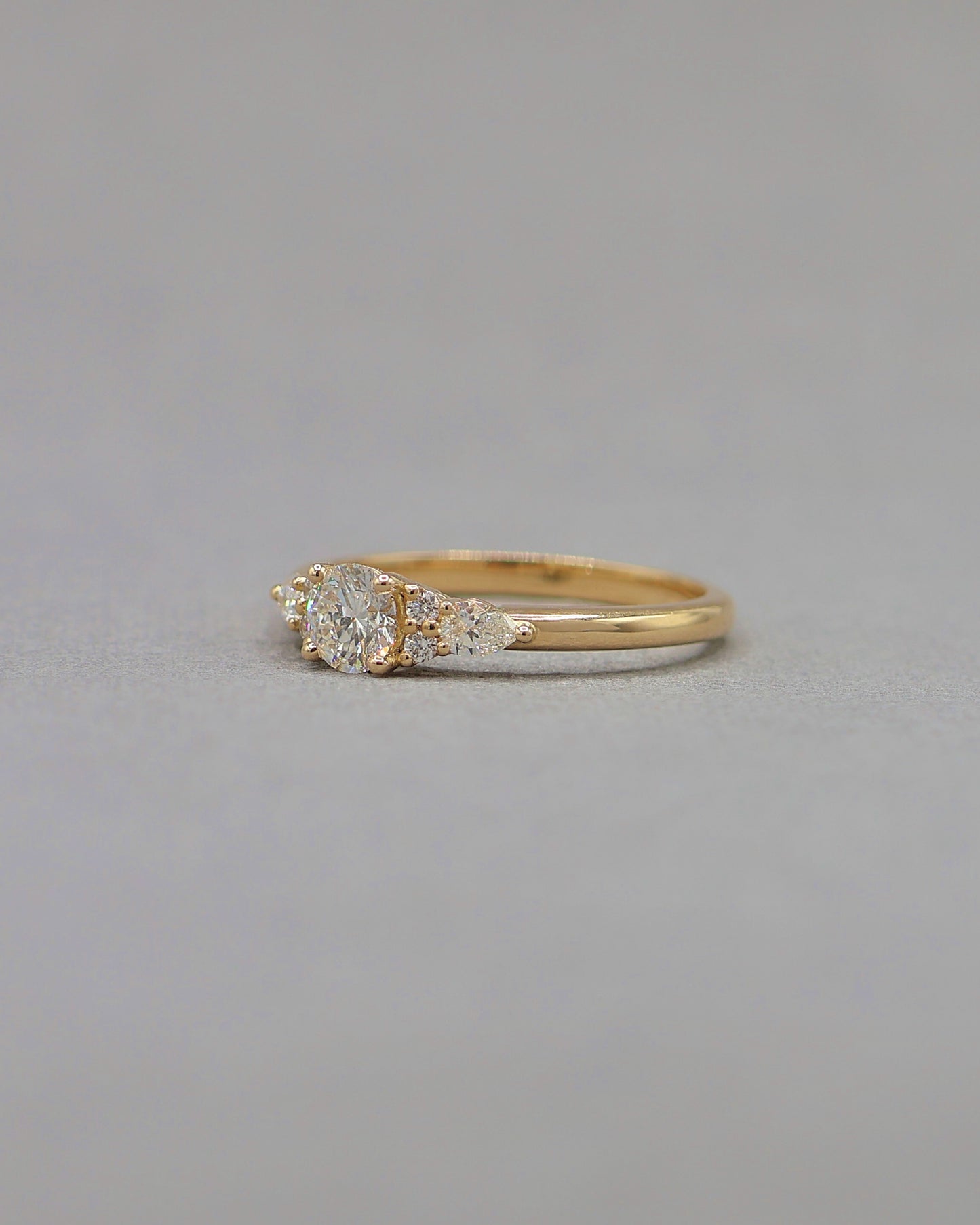 vue de cote d_une bague solitaire diamants epaule de diamants taille brillant et taille poire-bague de fiancailles en or jaune 18k
