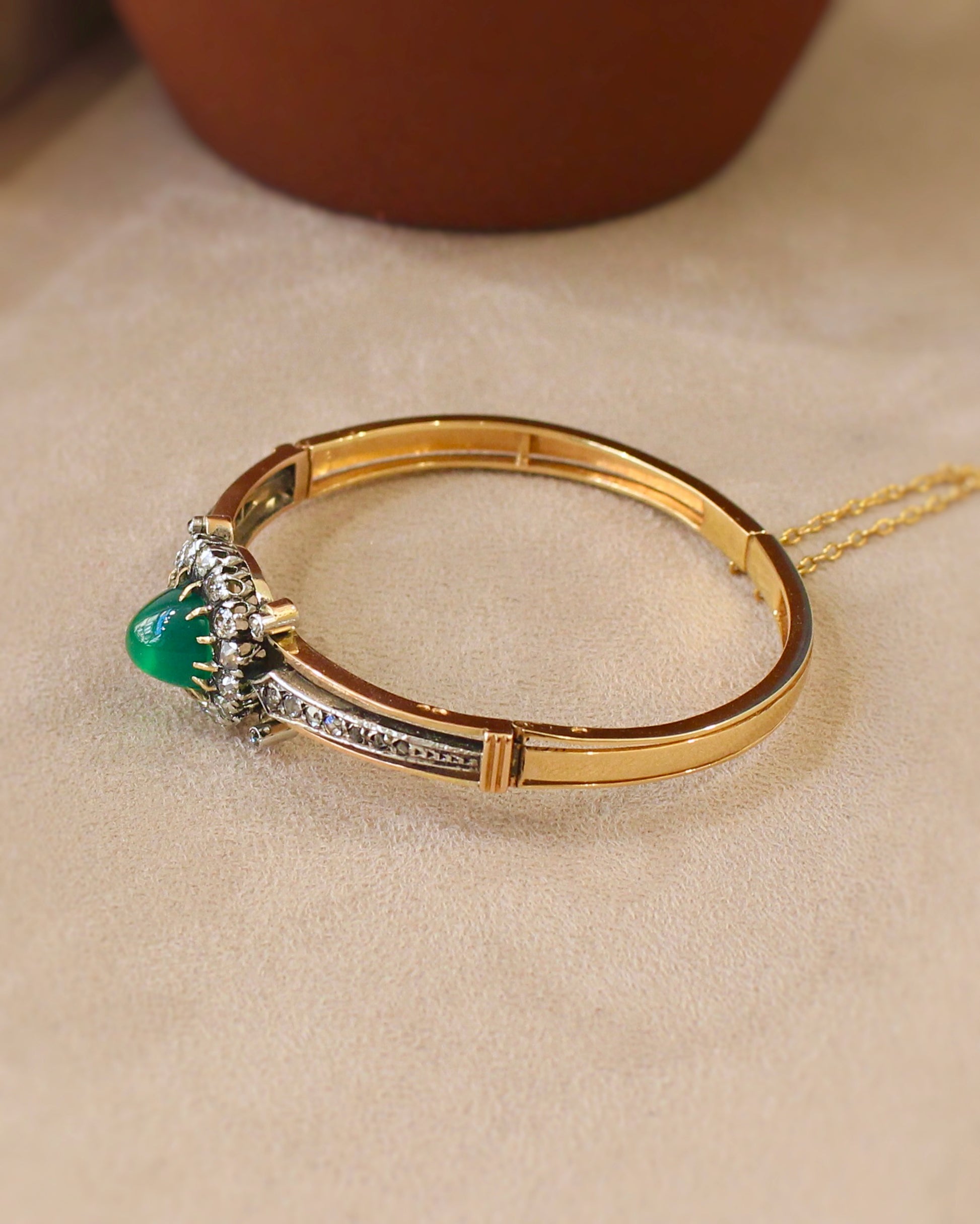 vue de coté d'un bracelet ancien - jonc ouvrant en or rose et argent avec cabochon de chrysopase entouré de diamants