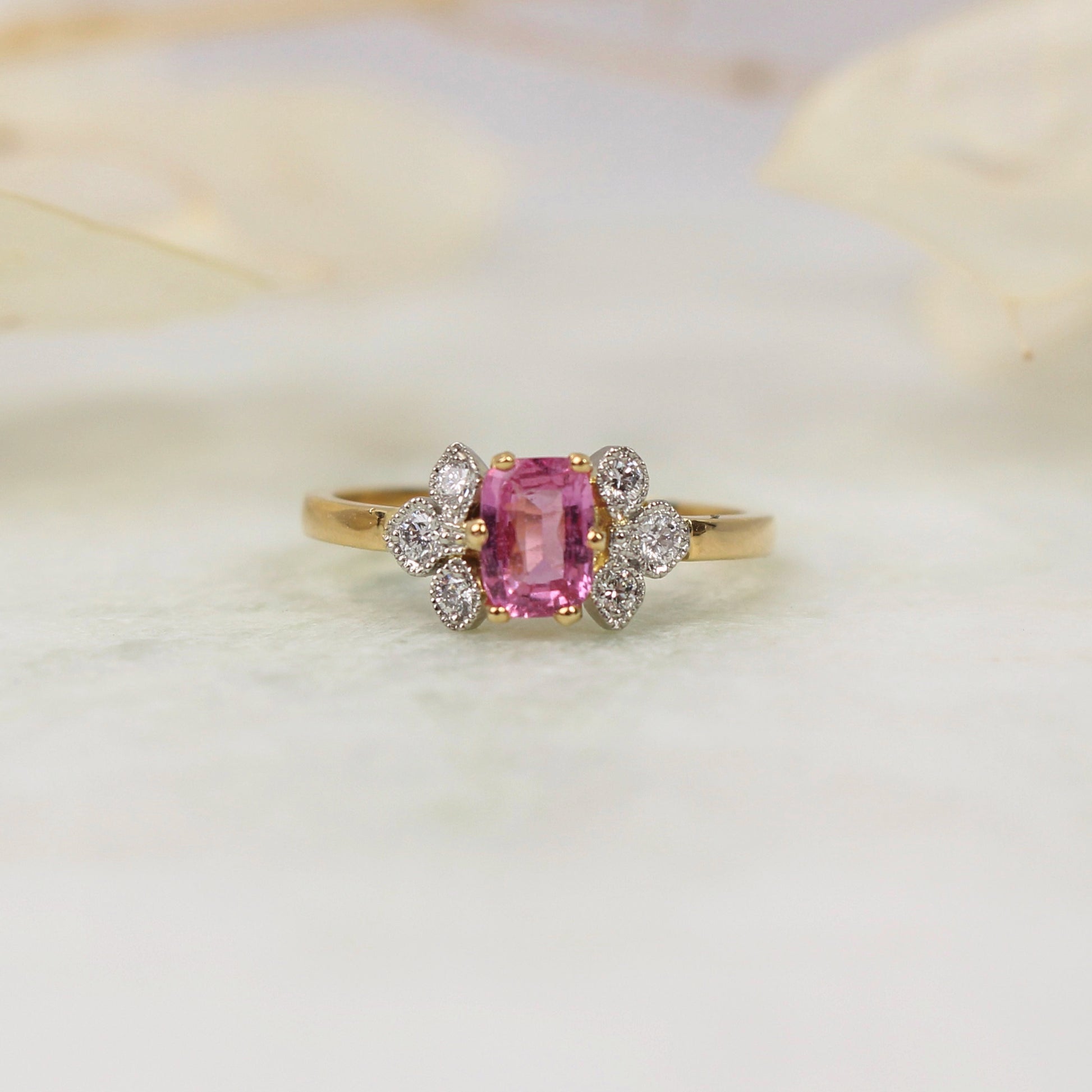 Bague de fiancailles avec un saphir rose taille coussin et une trilogie de diamants en serti clos perle de chaque cote-monture en or jaune et platine