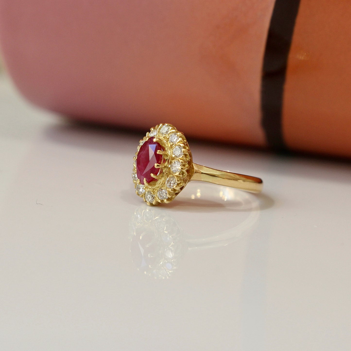 bague marguerite ornée d'un rubis en son centre entièrement entouré de diamants, monture en or jaune 18k