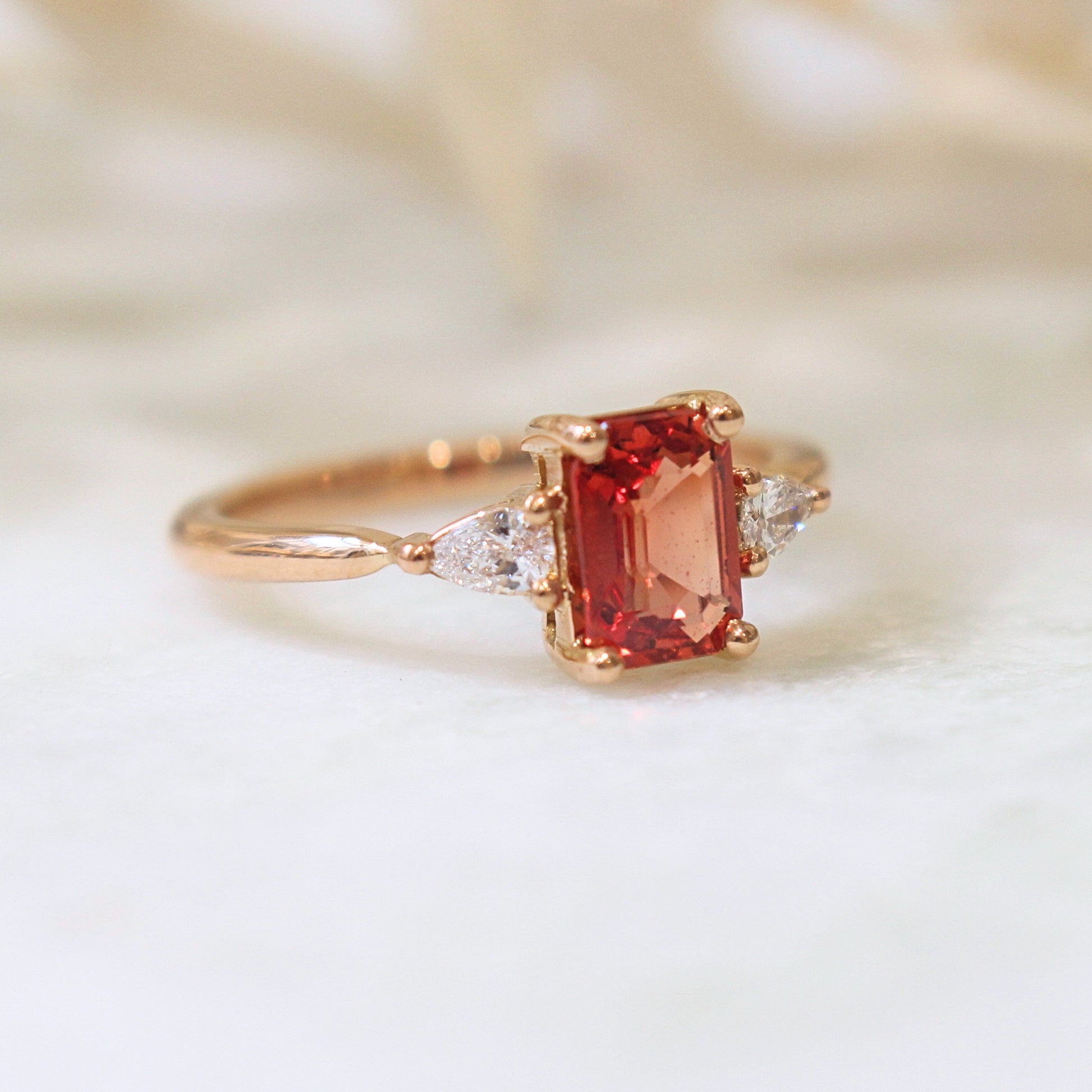 Solitaire saphir orange epaule par des diamants taille poire-monture en or rose18k