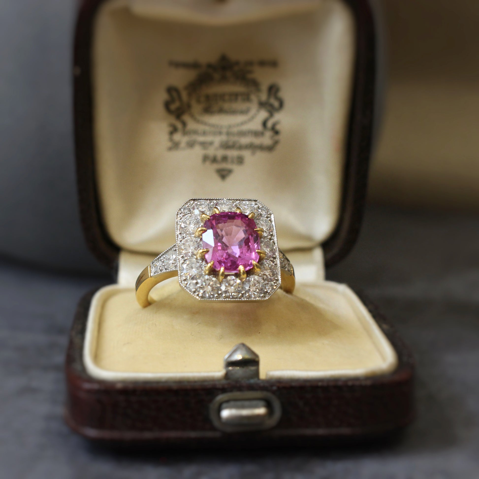 Un saphir ovale d'un rose intense, entouré de diamants taille brillant, pour une bague de fiançaille au carctère affirmé