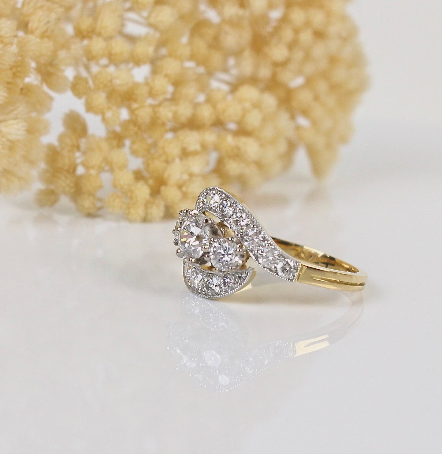 Une trilogie de diamants au centre de cette bague tourbillon en or jaune te platine