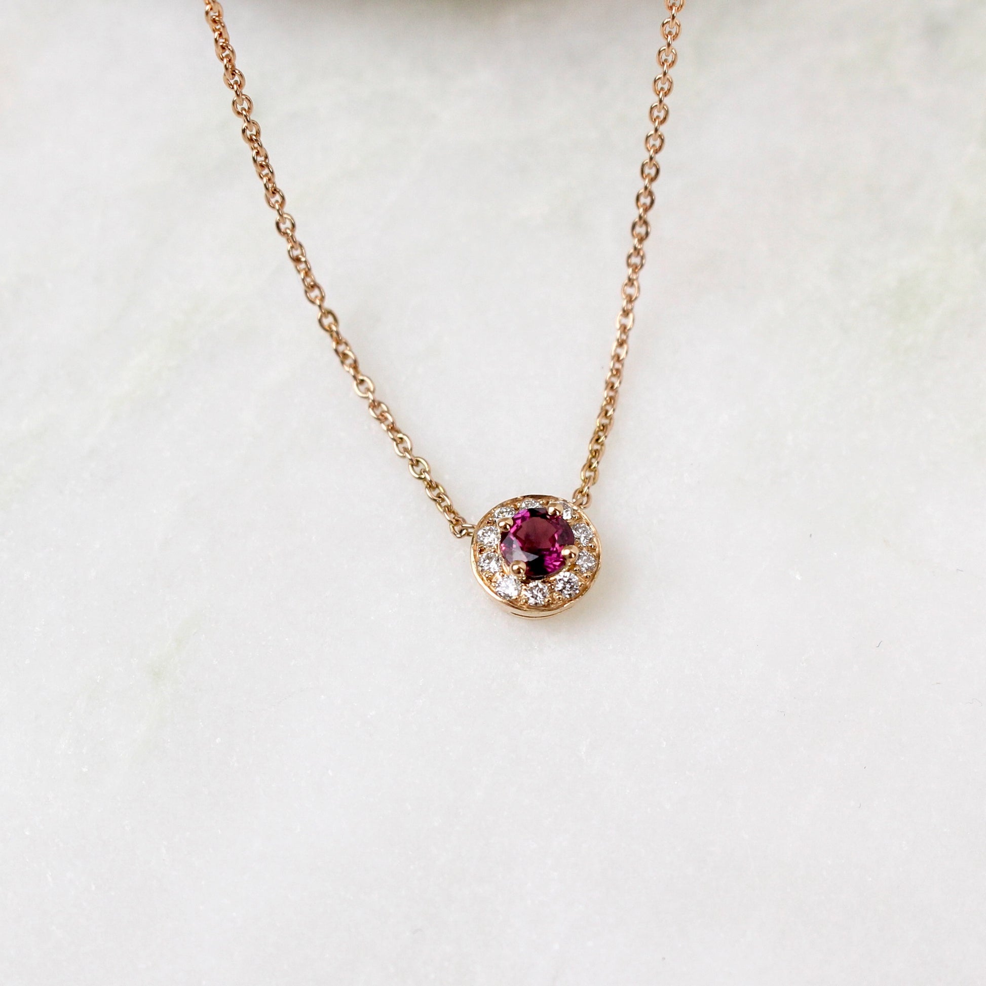 Un collier avec un saphir rose de 4mm entierement entoure de diamants sur de l_or rose18k