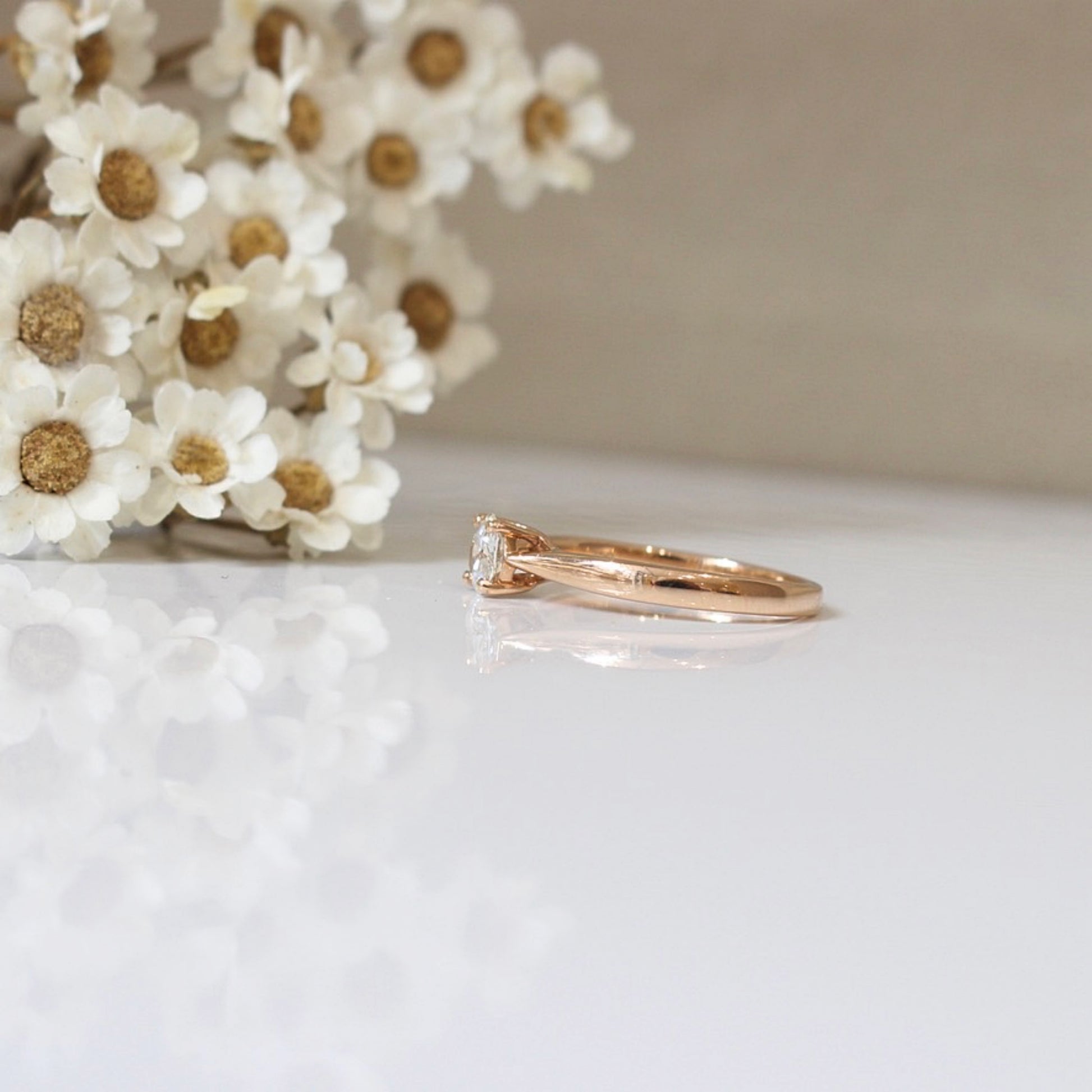 Bague fine en or rose ornée au centre d'un diamant serti griffes