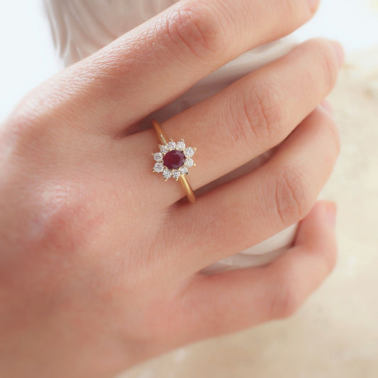 bague marguerite avec un rubis taille ovale entouré de diamants taille brillant.monture en or jaune 18k