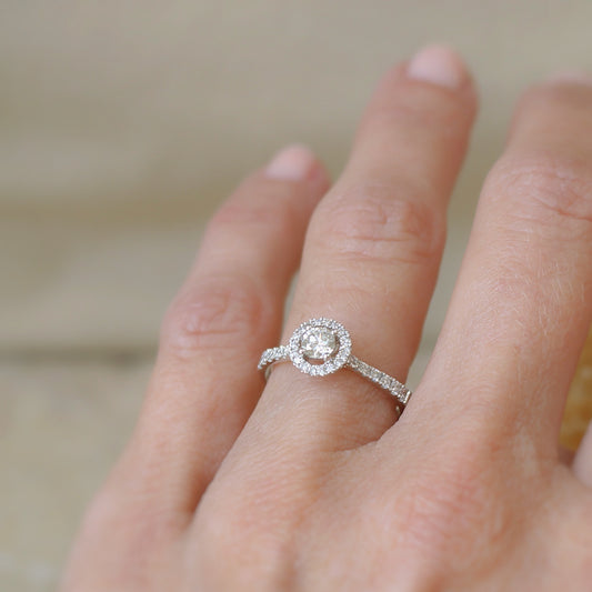 Magnifique bague de fiançailles avec ce solitaire diamant entouré d'un halo de diamants et une descente de diamants sur l'eau de la bague