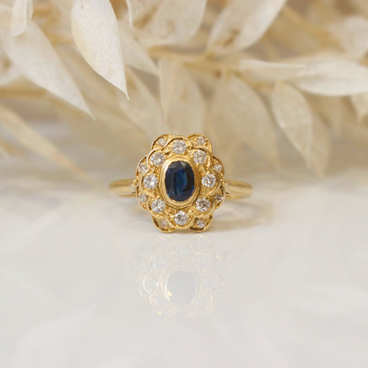 Petite bague marguerite avec saphir en son centre entouré de diamants en serti demi-clos/or jaune 750/1000